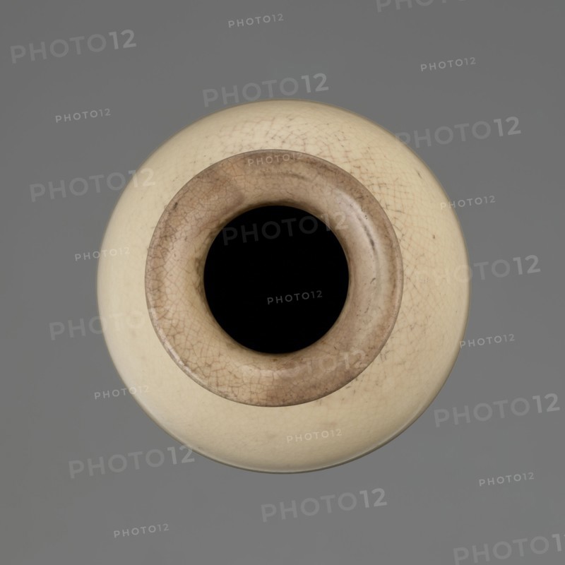 Cylindrical porcelain vase tapering toward the bottom with a flat rim; light cream glaze with fine cracklework. Wooden round flat saucer on three legs. 19th century, Japan; ceramics; Japanese Edo period. Vessel. Height 21.1 cm; diameter 8.4 cm; weight 0.6 kg., A round vessel viewed from above with a dark central opening surrounded by a rim in shades of brown and beige, the body of the vessel in a creamy off-white with fine crackle patterns, set against a uniform gray background; visible colors include black, brown, beige, creamy off-white, and gray.