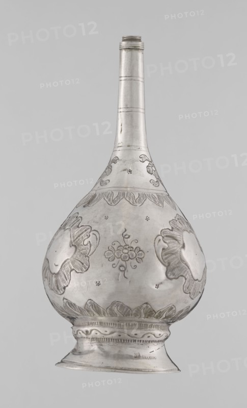 Bottle for spraying water soaked in perfumes, Islamic art, Islamic culture, vessel with plant and floral ornament; decoration: multi-leafed undecorated cartouches alternating with small flowers. 19th/20th century, possibly Turkey or North Africa. Weight 113 g, height 17.5 cm, diameter 8.0 cm., A metallic vessel with a long narrow neck and a bulbous body standing on a flared foot, shown against a plain light gray background; the vessel is silver in color with engraved decorative motifs including floral and leaf-like patterns and textured shaded areas, with several scalloped border designs around the widest part and base, and the surface shows subtle scratches and variations in sheen.