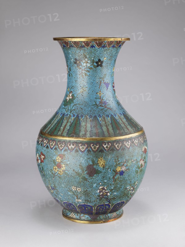 Vase, Qing style, Chinese culture, Chinese art, Qing 1644–1911; 18th/19th century, China. Porcelain vessel with a thick cylindrical neck and a flared spout, decorated with chrysanthemums, peonies, plum trees, meander ornament and plant motifs. Height 61.5 cm; diameter 25.7 cm; weight 10.0 kg., A rounded decorative vase with a flared neck, shown against a neutral gray background, featuring an overall turquoise-blue ground covered with an interlocking geometric pattern and scattered floral motifs; the body displays painted flowers in colors including white, yellow, red, purple, and dark blue, with green foliage; a band of stylized leaf or feather forms in green and dark blue separates the neck from the shoulder, and a repeating heartlike border in dark blue and white runs near the widest point; the rim and foot are highlighted with metallic gold-colored bands, and the lower foot area includes a row of dark blue petal shapes with lighter blue accents; the surface shows areas of darker pat...