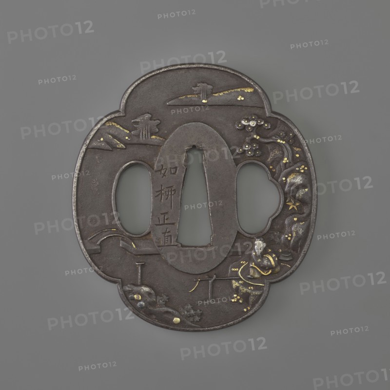 Crossguard tsuba, sword crossguard, landscape motifs, tsubas, fishermen, Japanese art and culture, weapons, melee weapons, swords, katana, bridges, rocks, plants. Plastic decoration: obverse — fisherman sitting by the water against a landscape background; reverse — landscape. 19th century, Japan European copy. Tsuba, height 6.9 cm, width 6.3 cm, depth 0.4 cm., A dark metal, cloud-shaped object with an oval central opening and two rounded side openings rests against a neutral gray background, showing a surface adorned with small inlaid areas of gold and silver that form decorative accents; the metal has a matte, slightly worn dark brown to black patina, with raised and incised ornamental motifs including rounded forms, floral shapes, and curved lines, and a few brighter metallic highlights where the gold and silver are applied.