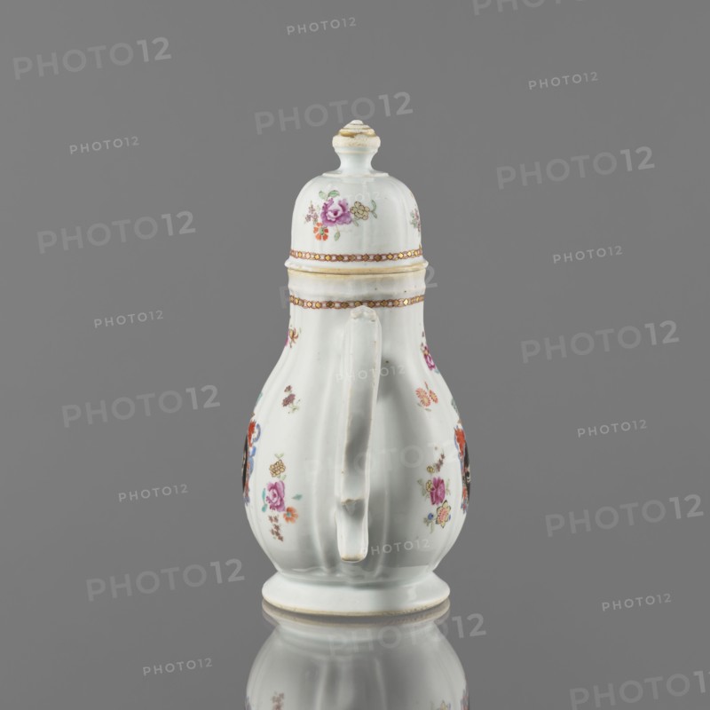 Jug with a lid, ceramics with enamel paints, Canton China, Qing style, Chinese export porcelain, colored porcelain decorated with European coat of arms: white griffin on a black field surmounted by four, batons; 19th century, Canton export product, vessel; height 21.2 cm, width 14.4 cm, diameter 10.4 cm., A white ceramic vessel with a lid and a curved handle, decorated with small floral motifs in pink, purple, red, orange, yellow, green, and blue, and banded with thin gold accents; the surface shows a glossy finish and the object sits on a round base reflected on a smooth gray surface against a solid gray background.