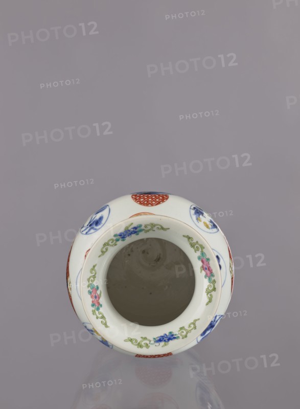 Vase by Tashiro, Japanese, colored porcelain, ceramics; Meiji period 1868–1912, 2nd half of 19th century. Hizen Arita, Japan. Height 28.5 cm, diameter 19.0 cm. Decoration: figurative scenes with landscape background, peonies, camellias, wisteria, fish, pine trees, asanoha pattern; genre scenes. Provenance unknown., A white ceramic vessel viewed from above with a round open mouth, decorated around the rim with a floral garland in green, pink, blue, and teal, and additional circular motifs in red and blue on the outer surface; the interior appears plain and light grayish, and the background is a muted lavender-gray.