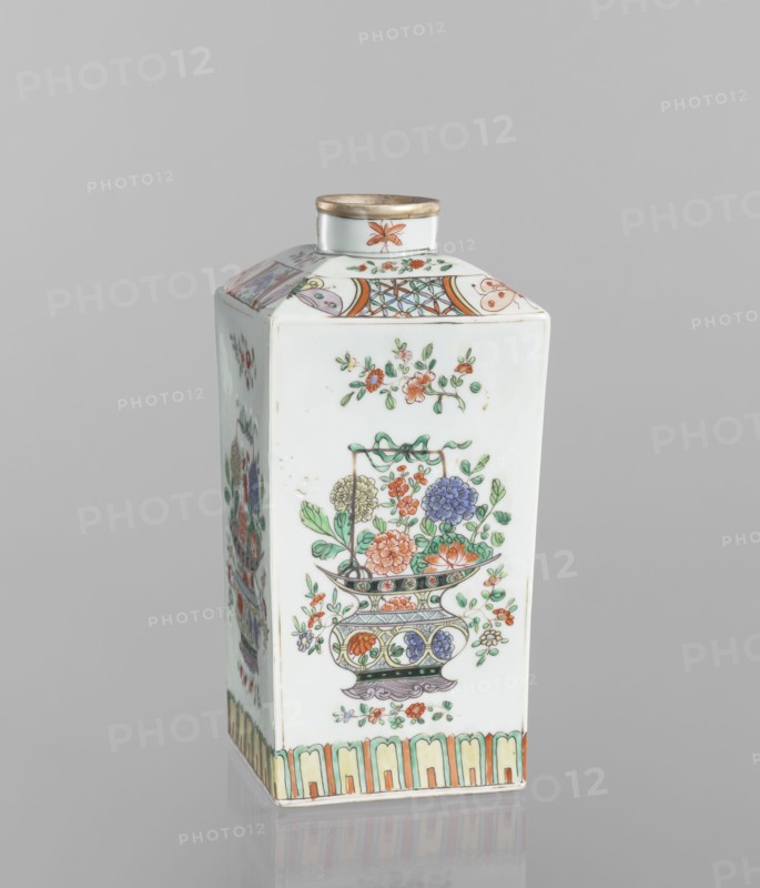 Bottle, Chinese, 18th century, porcelain vessel, decorated on each side with a basket of peonies, four flower sprigs and at the base of the belly a trail of lotus petals; on the shoulders with butterflies, trellises with flower rosettes and sprigs with flowers; on the neck four insects. Height 25.3 cm; width 10.8 cm; depth 10.8 cm. Materials: colored porcelain. Themes: peonies, butterflies, floral decorations, insects., A tall, rectangular porcelain container with a small round neck and rim sits against a plain gray background; the surface is predominantly white with painted floral decorations in green, orange, pink, blue, purple, yellow, and gold accents; one visible face shows a decorative vase motif filled with stylized flowers and leaves, with additional small floral sprigs above and below, and a patterned border along the base in soft green, yellow, and orange; the top panels display geometric and floral bands in similar colors, and the neck has a small floral motif and a gold-col...