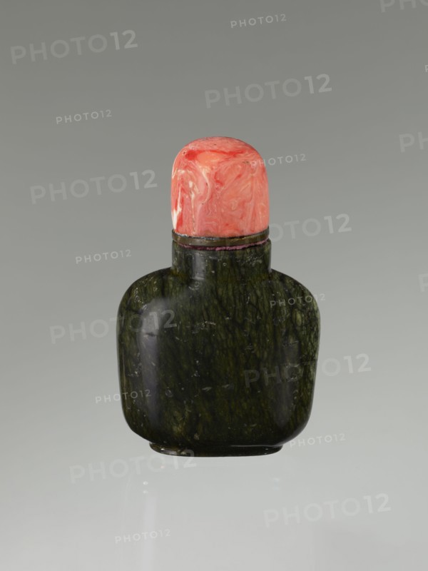Snuffbox with spoon, Chinese, Qing dynasty 1644–1911, 19th century. Moon bottle plug stone: rhodochrosite. Vessel; height 7.1 cm, width 4.6 cm, depth 2.6 cm., A small rounded bottle with a dark green, mottled stone body and a glossy surface is topped by a bulbous cap in swirled shades of coral, pink, and pale orange; a thin dark band separates the cap from the bottle, and the object sits against a smooth gray background with a faint reflection below.