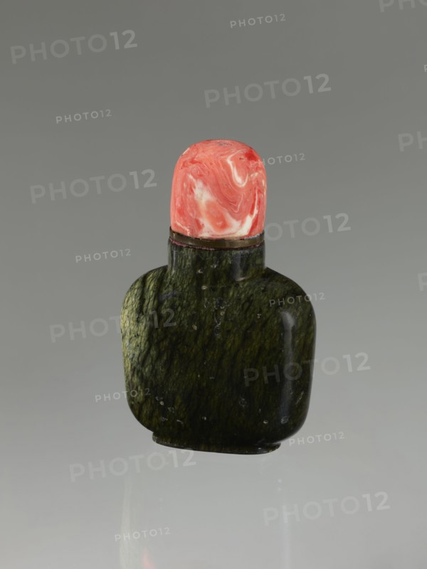 Snuffbox with spoon, 19th century China, Qing dynasty 1644–1911. Moon bottle carved from rhodochrosite plug stone; vessel with spoon. Height 7.1 cm, width 4.6 cm, depth 2.6 cm. Chinese art., A small rounded bottle with a dark green, mottled surface sits upright against a neutral gray background, topped by a rounded stopper that shows swirled shades of pink, coral, and white; the bottle has a glossy finish with subtle lighter green veining and a narrow darker neck band beneath the stopper, and a soft reflection appears on the surface below.