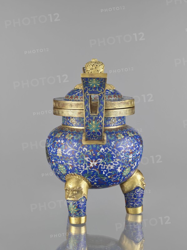 Ding-type incense burner with cover; cloisonné enamel; Qing dynasty 1644–1911, 19th century, China; motifs: bats, dragons, plant ornament, leiwen meander ornament; vessel; height 38.5 cm, width 34.5 cm., An ornate vessel with a rounded body and lid stands on three short legs ending in sculpted heads; the surface is covered in intricate floral and scroll patterns in bright blue with accents of teal, green, white, red, and gold, while bands, fittings, and the leg-heads are gilded with a yellow-gold tone, and the background behind the object is a uniform light gray.