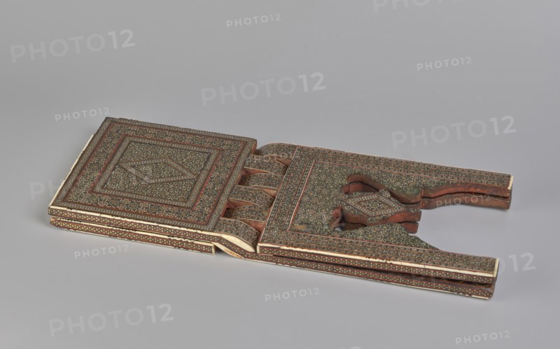 Quran lectern rahla, Islamic art, Persian art, Qajar dynasty 1785–1925, geometric ornament, stands, rahla, Quran, Persian culture, 19th century, Iran, piece of furniture; unfolded: length 21.5 cm, width 41.4 cm; folded: length 41.5 cm, width 16.5 cm, A flat decorative object with intricate patterned surfaces lies open on a light gray background, showing a pair of rectangular panels connected by hinged, curved sections; the surfaces feature dense small floral and geometric motifs in shades of brown, dark green, red, and cream with narrow borders and repeated designs, and the object has carved wooden edges and layered sides where the brown wood and cream inlay are visible.