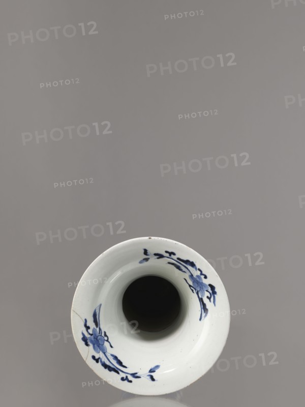 Vase, Japanese, Edo period 1603–1868, Genroku–Kyoho eras ca. 1690–1730, Arita blue-and-white porcelain vessel, decorated with phoenixes hoo, hares/rabbits, peonies, chrysanthemums, lotuses — kacho flowers-and-birds / kachoga iconography; one of four elements of a set SKAZsz 314/1–4; height 39.0 cm, diameter 20.3 cm., A top-down view of a white ceramic vessel with a dark interior and a rim decorated with blue floral motifs, set against a smooth gray background; the rim shows a visible crack and subtle surface imperfections, and the dominant colors visible are white, blue, dark black inside the vessel, and gray in the background.