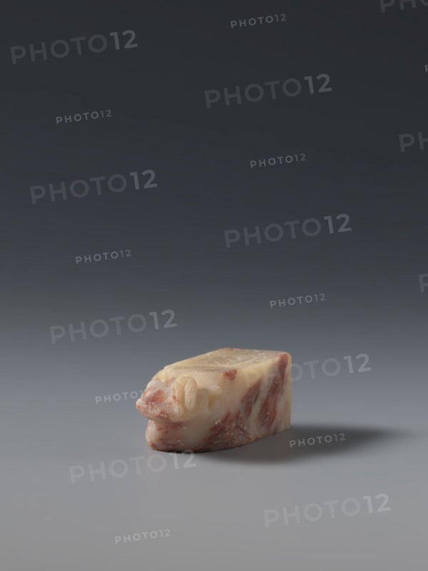 Seal stamp, maker, ; subject: hares; Chinese; medium: seal stamp sculpture; culture: Qing dynasty 1644–1911, late 19th century; origin: China; dimensions: height 5.7 cm, width 1.8 cm, thickness 1.7 cm., A small, irregularly shaped object sits on a smooth surface with a soft shadow extending to one side; the object shows a marbled pattern of pale cream and pinkish-red tones with a glossy, slightly translucent appearance and rounded, organic contours, while the background transitions from a lighter gray near the surface to a darker gray toward the top of the image.