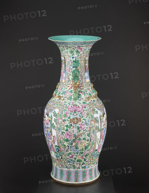Vase, lion iconography, protection, court scenes, ceramics, Qing style, colored porcelain, Chinese art, Chinese culture, decorative vessel, Qing 1644–1911, rim covered with turquoise paint on the inside, 19th century Qing dynasty, China, vessel, height 90 cm, diameter 37.5 cm, A tall ornate vase stands against a dark background, with a flared rim colored turquoise on the inside and a patterned turquoise band along the outer edge. The body of the vase is predominantly white and is densely decorated with floral motifs in pink and green, with additional flowers and leaves in shades of purple and pale yellow. Framed panels around the vase contain figurative scenes with clothing and skin tones in muted pinks and blues, and accents of light blue and pale lavender appear throughout. There are gilded decorative elements in a metallic gold color near the neck and shoulders, and the lower rim features a repeating decorative band in turquoise and pink with touches of gold. Overall the visible col...