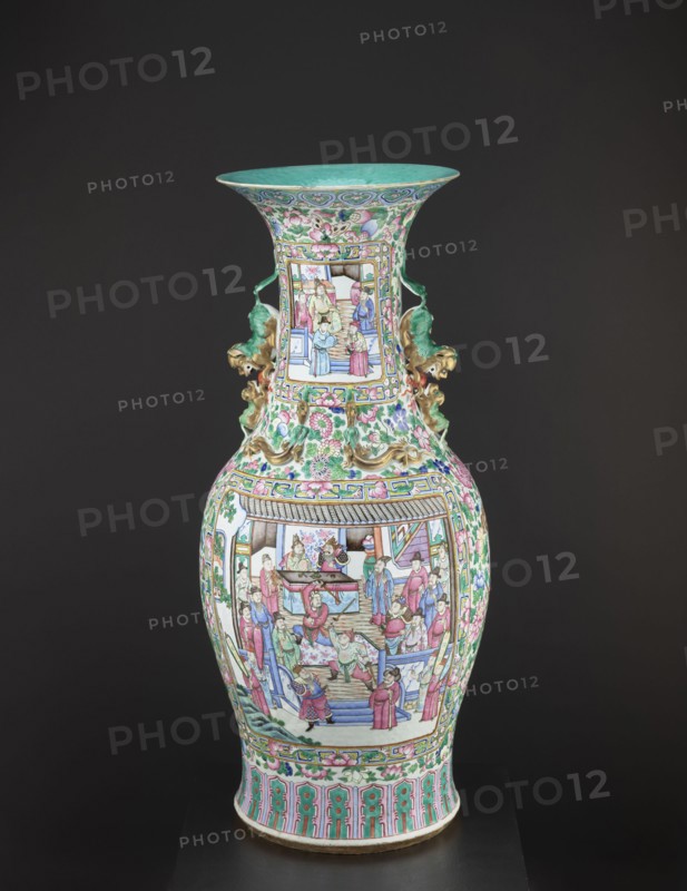 Vase, lion iconography, protection, court scenes, ceramics, Qing style, colored porcelain, Chinese art, Chinese culture, decorative vessel, Qing 1644–1911, rim covered with turquoise paint on the inside, 19th century Qing dynasty, China, vessel, height 90 cm, diameter 37.5 cm, A tall decorative vase with a flared rim sits against a dark background; the vase is covered in intricate painted scenes and floral patterns showing a group of people in an interior and exterior setting, with ornamental borders and stylized flowers. The vase has a predominantly green and pink color scheme with accents of turquoise, blue, white, gold, and touches of red and purple. There are sculpted handles on the neck that appear leaf-like or dragon-like in form with a gold finish. The body narrows at the neck and widens at the shoulder and base, and the painted panels are framed by geometric and floral bands in matching colors. The rim interior is turquoise, and the lower foot features repeated vertical decorat...