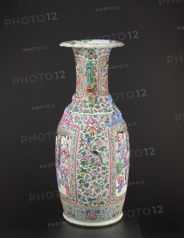 Vase, collateral provenance, manor property Ruchna; Chinese art; Chinese culture; Qing 1644–1911; colored porcelain ceramics; subject: lizards and lion iconography; Qing style; figurative and genre scenes; plant motifs with fruit in the background; decorative vessel vase; 2nd half of the 19th century; China; vessel; height 90 cm; diameter 37.5 cm, A tall, ornate porcelain vase sits against a dark background, featuring a flared rim and a long neck that widens into a bulbous body; the surface is covered in intricate painted and raised decorative motifs including floral patterns, scrolling foliage, and framed narrative panels with human figures, as well as sculpted dragon-like handles and ornamental applied reliefs. The visible colors include white as the base, with prominent greens and pinks in the floral decorations, accents of blue and purple in some raised elements, and touches of yellow and red used in borders and details, along with gold-toned highlights. The overall appearance is r...