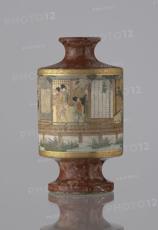 Vase, Kinkôzan Sôbei VII 1867–1927 and Kinkôzan workshop; gift; genre scenes; Japanese art; ceramics; vases; Japanese; wisterias, irises, bamboos; Meiji 1868–1912; vase in the shape of a sake bottle, on a stem; short, narrow neck; 19th/20th century Meiji period, 1868–1912; Japan, Kyoto; vessel; height 11.7 cm; diameter 6.5 cm., A cylindrical vase with a narrow neck and a flared mouth sits on a rounded pedestal base, both showing a mottled reddish-brown surface with lighter marbling. Around the middle of the vase is a painted scene framed by narrow decorative gold bands, depicting a group of people wearing patterned garments standing on a wooden veranda beside sliding screens, with hanging foliage and a water channel below showing green plants and flowering irises. The painted panel uses colors including gold, cream, pale blue, green, black, and soft reds, while the background of the image is a plain light gray.