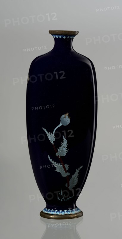 Vase, poppies; cloisonné enamel; Meiji period ca. 1900, 1868–1912; Japanese, Nagoya. Angular vase one of a pair with rounded edges, on a low round foot and with a short neck slightly flaring at the spout. The bottom of the foot and the edge of the spout are framed in silver-plated copper. Against a uniform dark garnet background with a purple hue, a decoratively but faithfully depicted tall flower grows from the base to the neck. Stems with alternating, elongated, jagged leaves in pale grayish green support large, full corollas of white and light purple flowers with dense yellow stamens and a green pistil; the motif is executed using the yusen technique, with thin silver wires structuring the delicate leaves and petals. Plant stems are accentuated with chocolate brown enamel. The flowers are presented slightly differently in each vase, enhancing naturalness. Around the foot and neck is a border of small geometric semicircle and rhombus motifs in white and two shades of blue, also in th...