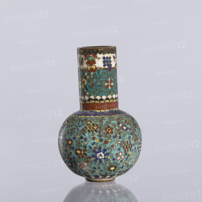 Vase, cloisonné enamel. Vase with a spherical belly and a long cylindrical neck decorated on the entire surface with small floral and geometric motifs on a turquoise background. Japanese, Nagoya; ca. 1880 Meiji Period, 1868–1912. Height 9 cm; diameter 5.7 cm., A small rounded vase with a narrow cylindrical neck decorated in a turquoise background covered with intricate floral and scroll patterns in colors including blue, red, white, green, gold, and pink, with a band of red and white near the base of the neck and a darker rim at the top, sitting on a reflective surface against a pale gray background.