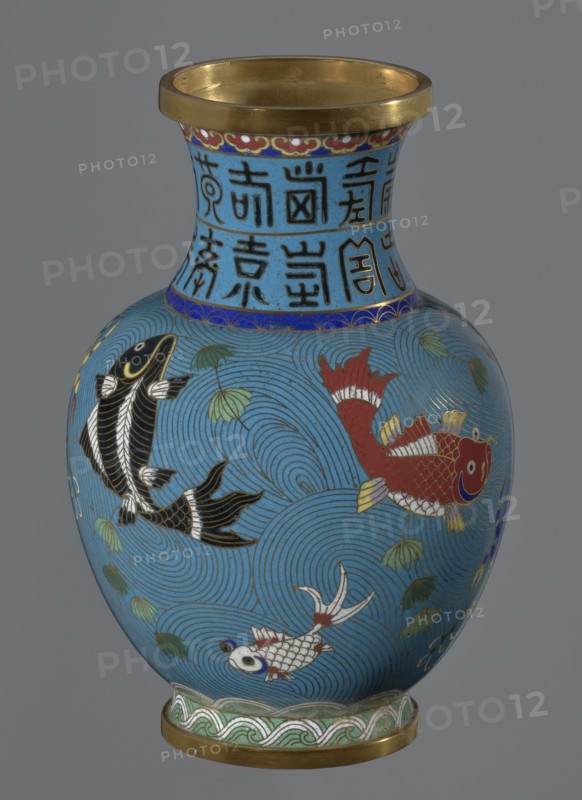 Vase, Chinese, Qing dynasty 1644–1911, 19th century. Cloisonné enamel on metal; vase on a foot with a neck. Decoration: fish and crabs on a turquoise background, archaizing inscription on the neck. Height 23.2 cm; diameter 9.1 cm., A rounded vase with a flared rim and a narrow neck, decorated on a bright blue background with swirling wave patterns and a few stylized green leaves; the neck has a band of dark blue and a section with dark linear characters on the blue ground that are not described, and a thin decorative border beneath the rim in red, gold, and white; the body shows a group of fish in different colors—a red fish with gold and white fins, a black fish with white accents, and a white fish with red and blue details—outlined in gold and surrounded by concentric circular wave motifs; the base and rim edges have gold-colored metal bands and the foot has a green and white wave-patterned band.