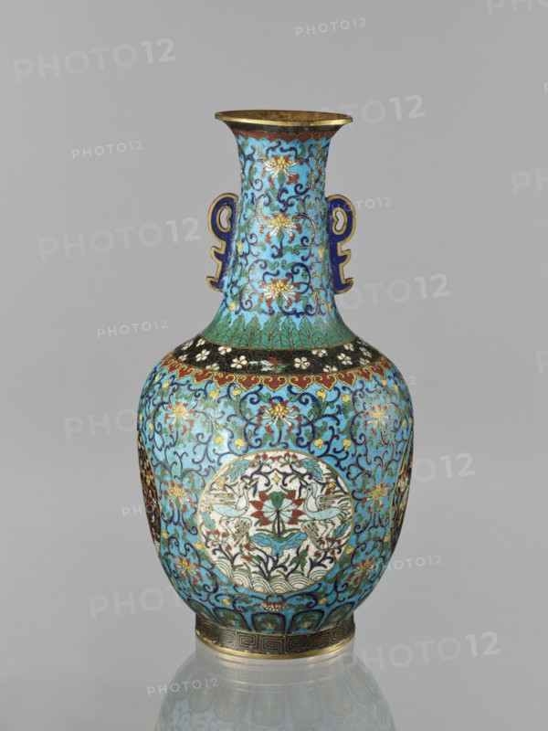 Vase, Chinese, Qing dynasty 1644–1911. Cloisonné enamel. 19th century. Vase with a neck; height 33.0 cm, diameter 15.0 cm, weight 1.7 kg. Decoration: floral and plant tendrils on a turquoise background; birds and animals in circular medallions on a plant background; cranes, deer, peonies, lotuses, chrysanthemums, tigers and other zoomorphic motifs; meander and lotus tendril ornaments. Two stylized handles on the sides of the neck., A single ornate vase with a flared rim and a pair of stylized handles, decorated all over with swirling floral and foliate patterns. The dominant color is bright turquoise blue, with accents of gold, deep blue, green, red, white, black, and touches of brown. The neck and body display repeating scrolling vines and stylized flowers, and there are circular medallions on the body containing symmetrical bird and floral motifs rendered in white, red, green, and gold. The rim and base have metallic gold bands and patterned borders, and small areas of dark blue outl...