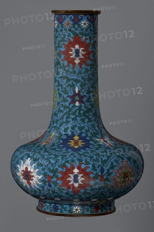 Vase, Chinese, Qing dynasty 2nd half of the 18th century. Cloisonné enamel vessel with a long, wide neck, supported on a separate ring-shaped foot and a flattened spherical belly. Main decoration: dense, multicolored lotus tendril covering the entire surface. Foot decorated with an ornamental band of small flowers and leaves. Upper edge of the neck at the rim decorated with a border of ruyi-head motifs. Neck ends with a thick, ungilded metal ring. Height 37.8 cm; diameter 15.5 cm., A tall bulbous vase with a long narrow neck decorated all over in a repeating floral and scrolling vine pattern in shades of blue, turquoise, teal, red, white, yellow, green, purple, and brown, featuring stylized multi-petaled flowers and leaf-like motifs on a gray background.