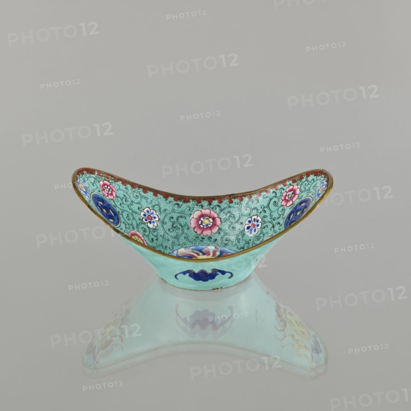 Bowl, painted enamel on vessel, Qing dynasty 1644–1911, 18th–19th century China. Decoration: boats, bats iconography, lotuses, coins, floral tendril; symbols of happiness. Dimensions: height 6.3 cm, width 8.5 cm, depth 15.3 cm., An ornate shallow bowl with a curved rim decorated on the inside with floral motifs in pink, blue, white, and green against a turquoise background with intricate dark green swirls and a gold-trimmed edge, the exterior showing a pale turquoise surface with a blue decorative emblem, all reflected faintly beneath the bowl; visible colors include turquoise, green, pink, blue, white, gold, and red.