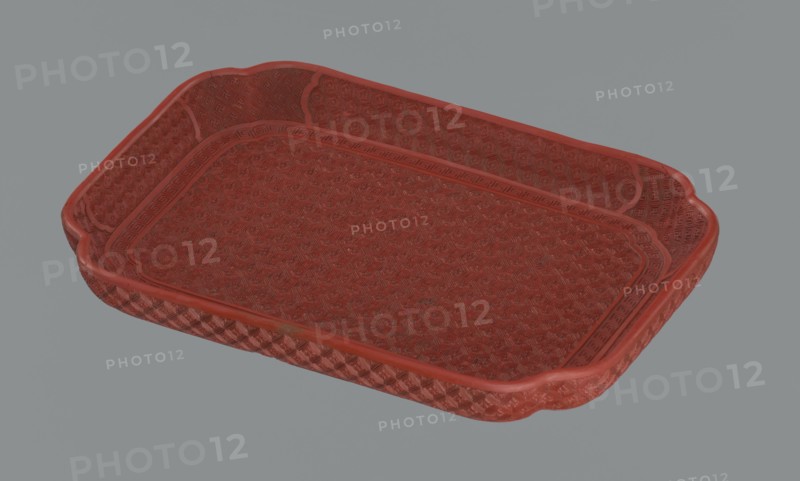 Tray, Qing dynasty 1644–1911, China; 18th–19th century. Porcelain vessel, height 2.0 cm, width 17.6 cm, depth 12.8 cm. Decorated with leiwen ornament, meander ornament, swastika iconography, kikko pattern, and geometric ornament., A shallow rectangular tray with rounded corners and raised edges, shown against a plain gray background; the tray has an intricate textured pattern across its bottom and inner sides, and a decorative border along the rim; the surface appears worn in places and the visible colors are shades of red and gray.