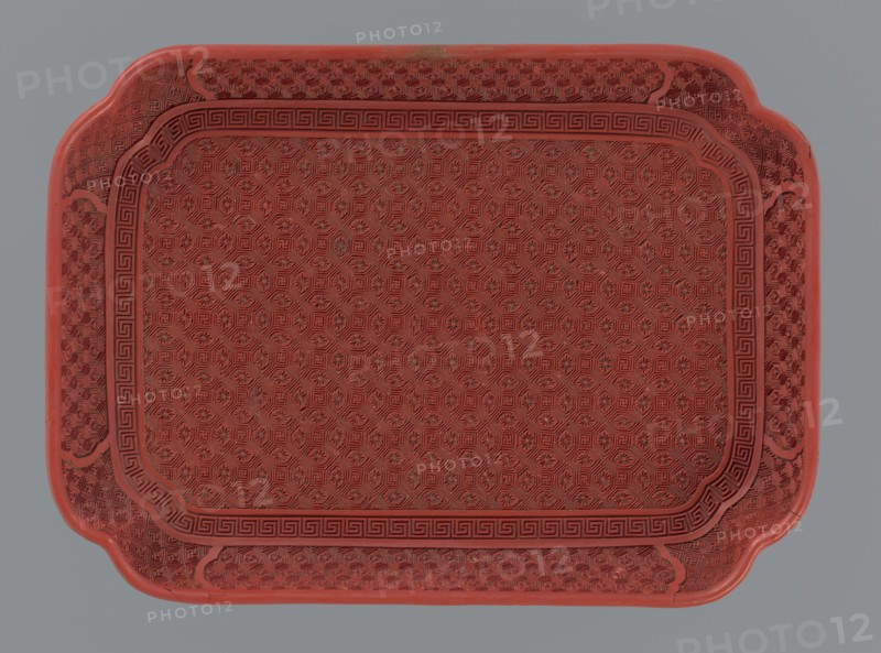 Tray, gift, Chinese art, Chinese, Qing 1644–1911, leiwen ornament, meander ornament, swastika iconography, kikko pattern, geometric ornament, 18th–19th century, China, vessel; height 2.0 cm, width 17.6 cm, depth 12.8 cm, A rectangular tray with rounded corners and scalloped edges, predominantly red with subtle darker red detailing, featuring an all-over repeating geometric and floral embossed pattern across its surface, a bordered inner panel with a Greek key style motif, and a background that is a flat muted gray.