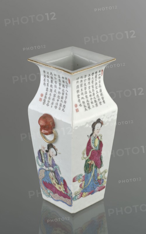 Vase with two handles, Chinese, Qing dynasty 1644–1911, 19th century. Porcelain fragment with white transparent glaze; decoration painted with overglaze enamel paints and iron red. Subjects: lion iconography, figural scenes, images of women. Colored porcelain. Inscriptions. Vessel, height 28.5 cm, width 15.2 cm, depth 11.5 cm, weight 1.75 kg., A square-topped porcelain vessel with flared rim and a pale gold trim sits against a neutral gray background, showing a glossy white surface decorated with painted figures and calligraphic bands. One visible side features a standing woman in traditional garb with garments in red, green, blue, and yellow, accented with black hair and pale skin tones, standing on stylized cloud motifs in pink, blue, and yellow. An adjacent side shows a seated figure in robes primarily purple, blue, and yellow with red and green accents, also positioned on colorful cloud-like forms and a patterned base. Another face includes a small sculpted red lion head with a gol...