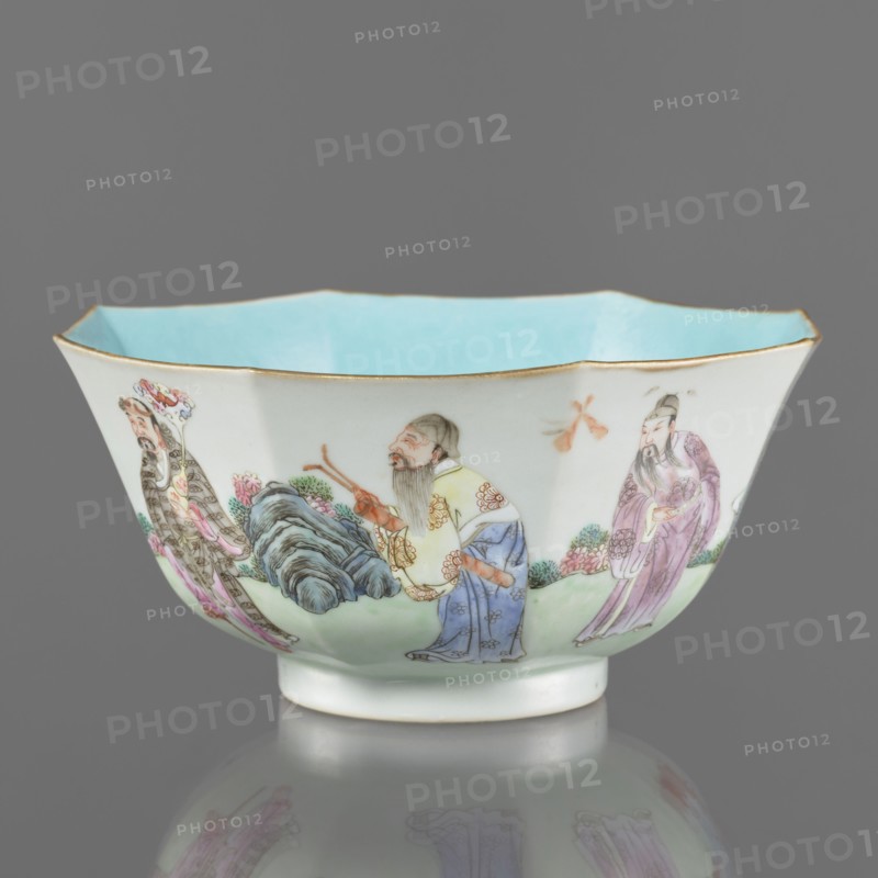 Bowl. Spherical bowl on a ring foot. Porcelain body; turquoise and transparent white glaze. Decoration painted with enamel paints and iron red depicting the Eight Immortals iconography. Colored porcelain, Qing dynasty, Jiaqing period 1796–1820, 18th/19th century China. Height 8.1 cm; diameter 17.6 cm; weight 0.4 kg., A shallow, scalloped bowl with a pale blue interior and a thin gold rim sits against a gray background; the exterior is white with hand-painted scenes showing a group of bearded figures in traditional robes in colors including yellow, blue, purple, pink, and green, standing near stylized rocks and flowering plants in shades of green, pink, and pale blue, with delicate brushwork and fine detailing on faces and garments.
