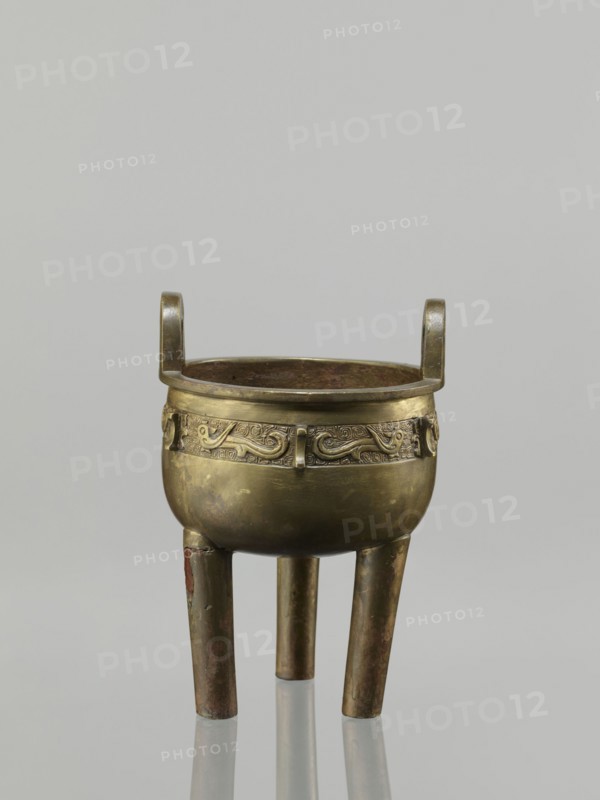 Ding incense burner, leiwen ornament, Ding vessel, ritual/ceremonial vessel with bird decorative motif and meander ornament, Chinese, Qing dynasty 1644–1911, 19th century, China; height 19.2 cm, diameter 13.6 cm;, A small bronze vessel with a rounded body and a band of low relief decoration around its upper circumference sits on three straight legs and has a pair of short, upright handles opposite each other; the bronze surface shows areas of darker patina and lighter golden tones with traces of brown and greenish discoloration, and the interior appears darker with mottled brown and green hues, all set against a plain pale gray background.