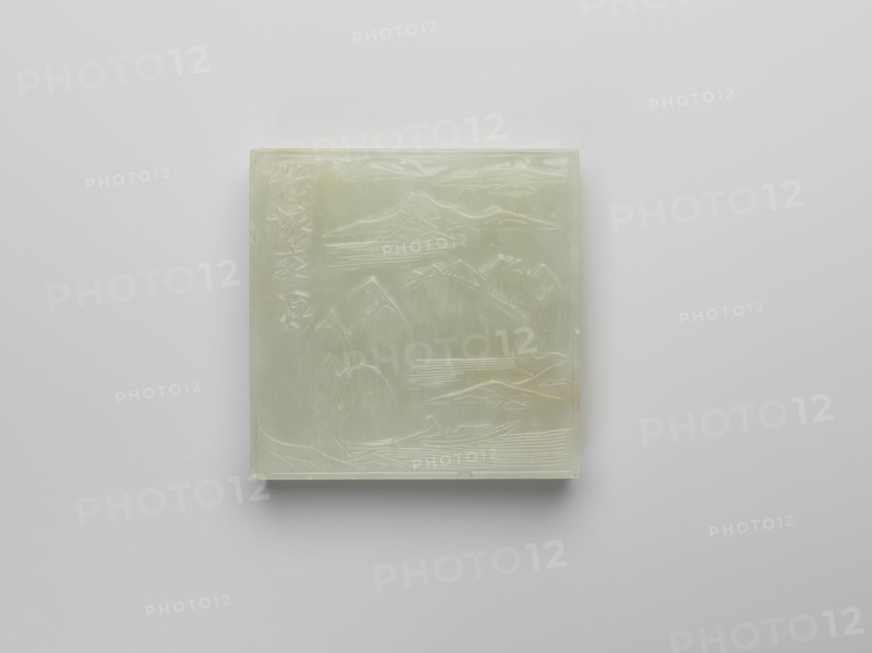 Plaque, Chinese, Qing 1644–1911, landscape motifs with fishermen, engraving of a rock, pale green jadeite, 19th century, plaque; buttonholes on the reverse; height 5.1 cm, width 5.1 cm, thickness 0.8 cm., A square, pale greenish-white carved stone panel with a glossy surface rests against a light gray background, showing a carved landscape scene with mountains, ridges, and a few flowing lines suggesting water; the carving includes subtle variations in the pale green and creamy tones, with slightly darker greenish areas and faint warm beige spots, and the panel casts a soft shadow on the background.