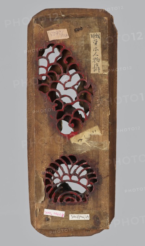 Gate of Emperor Yu Dragon Gate - decorative panel, Chinese, Chinese art; iconography: fish, dragons, waves, fantasy animals/beasts. Elongated rectangular carved openwork ornamental panel. Qing dynasty 1644–1911, 19th century. Sculpture; height 3.7 cm, width 27.4 cm, depth 10.9 cm; provenance unknown., A tall, narrow wooden panel with rounded corners showing a worn brown surface and areas of lighter and darker brown; the panel has two decorative cutouts with scalloped, wave-like shapes painted along their inner edges in red, revealing a pale gray background through the openings; there are remnants of adhesive patches and peeling paper on the surface in beige and off-white tones, and a small piece of string or twine near the top; the wood shows scratches, chips, and aged texture with hints of darker stain around the cutouts and edges.