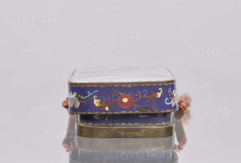 Letter box fubako with lid; maker, gift; Japanese art; Japanese; Meiji 1868–1912; cloisonné enamel box decorated with birds and chrysanthemums; late 19th century Meiji period; Japan; container; height 4.6 cm, width 23.0 cm, depth 8.8 cm, A small rectangular box with rounded corners resting on a reflective surface, showing a deep blue band around its sides decorated with floral motifs in red, gold, green, turquoise, white, and pink, with gold-colored metal edges and a brass-colored bottom, a portion of a woven cord in orange and red visible at the sides, and a pale top surface.