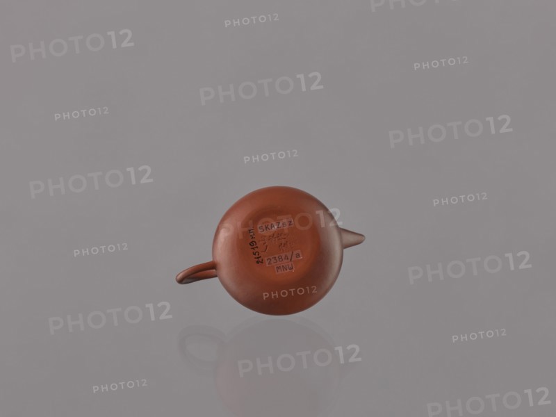 Teapot with lid;, ; Chinese art; Chinese culture; Qing dynasty 1644–1911; Yixing-style red stoneware teapot; 19th century; China, Yixing, Jiangsu; tea accessory vessel; height 6.1 cm, diameter 9 cm., A small round reddish-brown teapot with a short spout and a small handle sits centered against a smooth pale gray background, showing a subtle reflection beneath it; the surface of the teapot is matte and warm in tone, and the image contains shades of reddish-brown, pale gray, and a hint of darker brown.