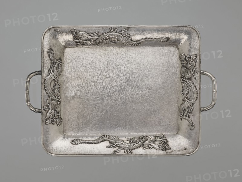 Tray, Japanese art, Japanese culture, dragons, Meiji 1868–1912, Japanese dragon motif, silver, bamboos, grained background decoration, early 20th century Meiji period, Japan, vessel, height 1.7 cm, width 30.8 cm, depth 21.2 cm, A rectangular metal tray with rounded corners and a textured surface, featuring a raised border with ornate dragon reliefs at each side and ends, and tube-shaped handles projecting from the shorter edges; the visible colors are silver and gray.