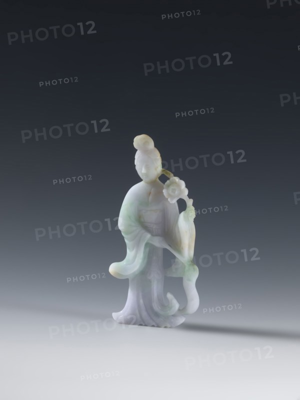 Taoist goddess?, Chinese, Chinese art, goddesses, Qing dynasty 1644–1911, Taoism, flowers iconography, scepters, green-pink slightly translucent jade, 2nd half of the 18th century, China, figurine sculpture, height 17.1 cm, A small carved figurine of a standing person with a rounded topknot hairstyle, flowing robes, and a graceful posture, holding a flowering branch; the material is smooth and slightly translucent with pale colors including white, light green, and soft lavender, with subtle yellowish accents, set against a dark gray to black gradient background and resting on a light gray surface that casts a soft shadow.