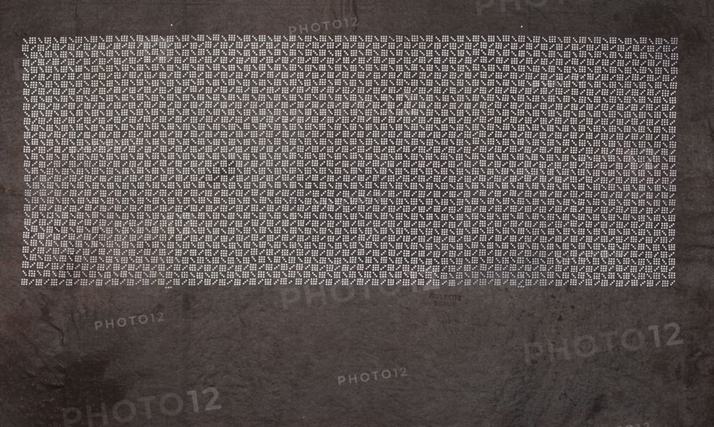 Katagami dyeing stencil with a stylized checkered pattern kawari ichimatsu, unknown author, ise-katagami stencil in chuban format, geometric checkered ornament, Meiji period, 2nd half of the 19th century Japan, stencil; height 41.1 cm, width 25.8 cm., A large dark textured surface fills the image with a rectangular area near the top made up of a dense grid of small light dots forming repeating geometric patterns, surrounded by the darker background. The visible colors are dark gray and black for the background texture and white for the dot pattern, with subtle variations of lighter and darker gray in the textured areas.