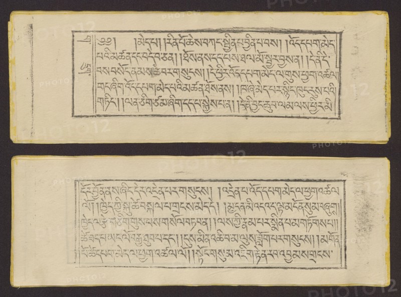 Buddhist text — Prayer for rebirth in the pure land of Sukhavati called Dechen Monlam, by master Raga Asja the first reincarnation of the Karma Chagme lineage Tib. rnam dag bde can zhing gi smon lam ra+a ga a syas mdzad pa bzhugs sto. Book in Tibetan pecha style, xylographic print in disciple script dbu can. Pages numbered on the recto side first page verso, 25 folios. 1 verso page and 2 recto illustrations. Edges tinted yellow. The original text of the prayer called Dechen Monlam Tib. bde chen smon lam, by master Raga Asja Tib. ra ga a syas, the first tulku of the Karma Chagme Tib. kar ma chags med reincarnation lineage, dates from the 17th century. 19th century, Tibet. Graphic. Width 25.5 cm, height 8.7 cm., A flat photograph of two rectangular cream-colored pages placed one above the other on a dark brown background, each page containing a framed block of closely spaced handwritten script in dark gray ink; the pages have slightly yellowed edges with a thin yellow border visible, and...