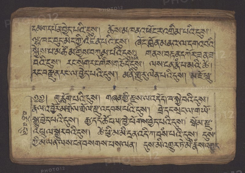 Buddhist Manuscript - Penitential Text Tib. sDig bshags gser gyi zhes bya ba bzhugs+o, unknown,  scribe-copyist author, Tibetan Buddhist art, Himalayan culture, Book in Tibetan pecha style, manuscript in student's script. Leaf numbering 2-22 verso, first recto, last two unnumbered. Handwritten notes folio 24 recto and verso. 19th century, Tibet, manuscript, width 24.0 cm, height 8.1 cm, A rectangular aged manuscript page sits against a dark background, showing a worn cream-colored surface with visible horizontal edges and layered pages at the top and bottom; the page has a few small dark spots and smudges, and there are several darker ink marks and ornamental strokes across the surface. The visible areas include a horizontal fold or crease across the middle and a thin ruled border near the top and bottom sections. The image shows a mix of black ink brushwork arranged in horizontal bands and vertical decorative strokes, with the ink varying in intensity in places. The page edges and lay...