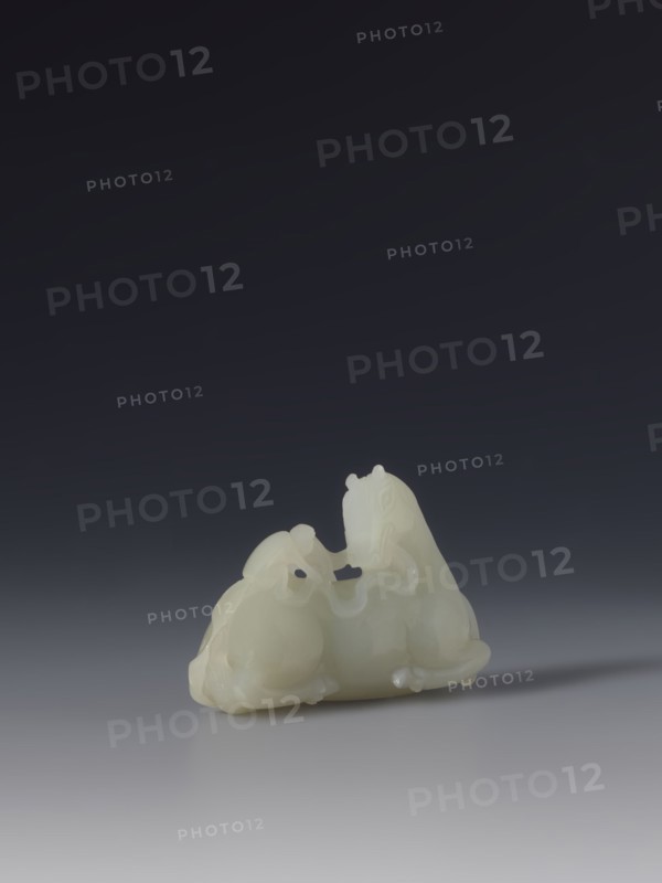 Paperweight — horse and monkey; maker, subject: horse and monkeys; materials/implements for painting; culture: Chinese; style/period: Qing 1644–1911, 18th–19th century; function: decoration; dimensions: height 6.6 cm, width 4.3 cm., A small smooth pale object with a creamy white color sits on a flat surface, carved into the shape of two rounded animals positioned close together with flowing curved lines and subtle raised details; the background is a gradient of dark charcoal to deep gray fading toward the bottom, and the surface beneath the object is a lighter gray that reflects a faint soft shadow.