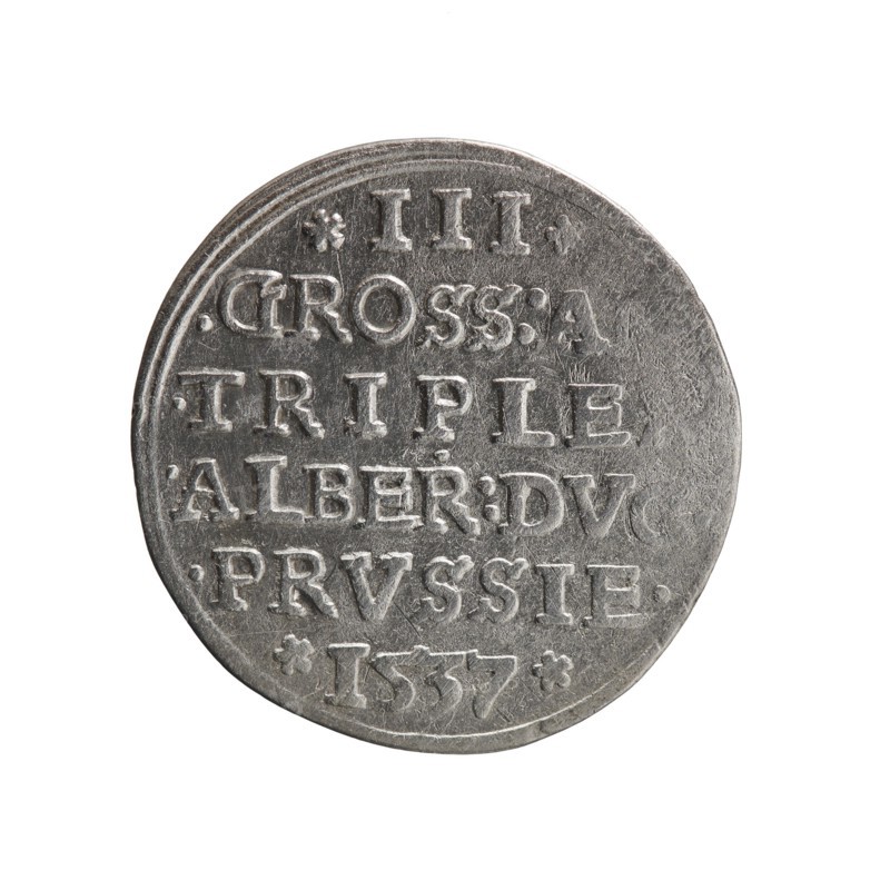 Trojak, Vogelwaider Vogelwaid, Eustachius mintmaster/publisher; Decius, Jost Ludwik fl. 1528–1535 mint manager/co-creator. Albrecht Hohenzollern Prince of Prussia; 1490–1568 — iconography: stars, male busts in armour. Obv.: male bust in armour in profile to right; short hair, beard with sideburns. In the rim the inscription *ALBER DG MAR BRAN ... PRVS; double continuous border, floral motifs between the words. Rev.: in the continuous border an inscription in six lines *III*/.GROSS:A. /.TRIPLE /.ALBER:DVC./.PRVSSIE./*I537*. Date: 1537. Place: Ducal Prussia 1525–1701, Königsberg mint. Coin; diameter 22.5 mm; weight 2.39 g; axis 30°., A round metallic coin with a worn silver-gray surface, showing raised lettering and decorative dots arranged in horizontal lines across its face; the coin edge is slightly irregular and the lighting highlights subtle scratches and textured areas on the metal, creating lighter silvery highlights and darker gray shadows.