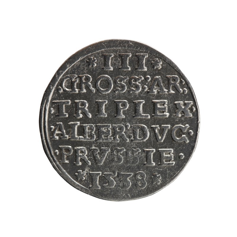 Trojak, Vogelwaider Vogelwaid, Eustachius mintmaster / publisher; Decius, Jost Ludwik fl. 1528–1535 co-creator / mint manager. Albrecht Hohenzollern Prince of Prussia; 1490–1568 — iconography: male busts in armour, stars. Obverse: male bust in armour in profile turned to the right; short hair, beard with sideburns. Inscription around the rim: *ALBER DG MAR BRAN DVX PRVS; continuous border, floral motifs between the words. Reverse: in the continuous border an inscription in six lines: *III*/.GROSS:AR:/.TRIPLEX./.ALBER:DVC./.PRVSSIE./*I538* 1538. Ducal Prussia 1525–1701, Königsberg mint. Coin; diameter 22.0 mm, weight 2.63 g, axis 170°., A round metallic object with a worn, textured surface sits against a white background; it has raised, blocky markings arranged in horizontal rows and a raised rim, and the metal shows areas of darker gray and lighter silver highlights with small scratches and scuffs.