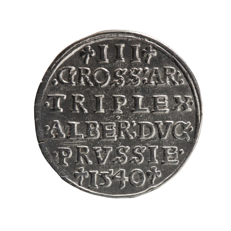 Trojak, Vogelwaider Vogelwaid, Eustachius mintmaster/publisher, Decius, Jost Ludwik fl. 1528–1535 co-creator/mint manager. Albrecht Hohenzollern Prince of Prussia; 1490–1568 — iconography: trefoils, male busts in armour. Obverse: male bust in armour in profile turned to the right; short hair, beard with sideburns. Inscription around the rim: *ALBER DG MAR BRAN DVX PRVSS; continuous border, floral motifs between the words. Reverse: in the continuous border an inscription in six lines: -III-.GROSS:AR:/.TRIPLEX./.ALBER:DVC./.PRVSSIE./-1540- the denomination and date are between the trefoil marks. 1540. Ducal Prussia 1525–1701, Königsberg mint. Coin; diameter 22.5 mm; weight 2.57 g; axis 45°., A round metallic coin with a worn silver-gray surface, showing raised lettering and decorative marks across its face; the coin edge is slightly irregular with a small chip visible, and the surface has areas of darker gray patina and lighter highlights that catch the light.