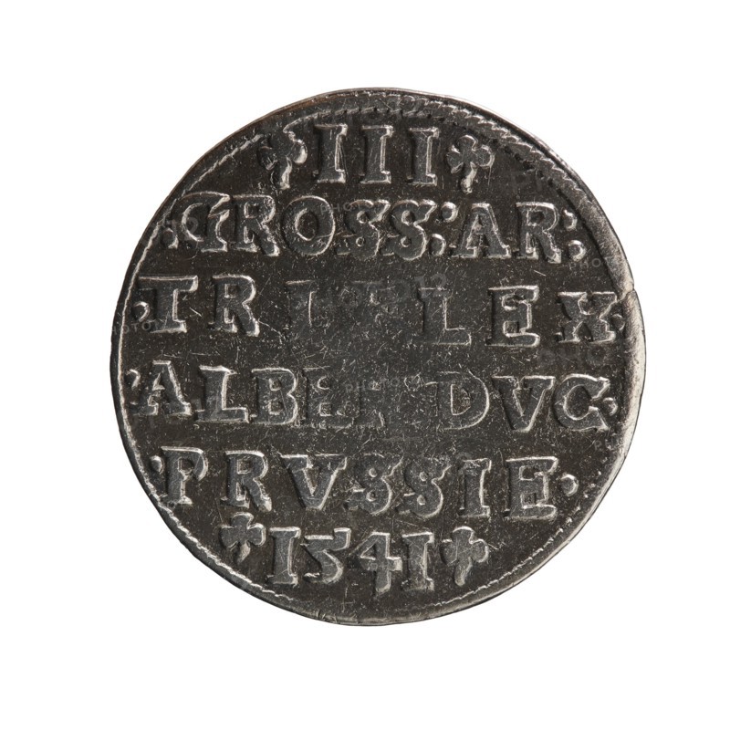 Trojak, Schilling, Maciej mintmaster; Decjusz, Jost Ludwik fl. 1528–1535 co-creator. Obverse: male bust in armour in profile turned right; short hair, long beard with sideburns; in rim an inscription beginning with a trefoil -ALBER D G MAR BRAN DVX PRVSS and a pearl border, plant motifs between the words. Reverse: in the pearl border an inscription in six lines -III-.GROSS:AR:/.TRIPLEX./.ALBER:DVC./.PRVSSIE./-I54I- with the denomination and date between trefoil marks. 1541, Königsberg, Ducal Prussia 1525–1701. Coin; diameter 22.7 mm, weight 2.43 g, axis 45°., A round metallic object with a worn, textured surface and a raised rim, shown against a white background. The object appears mostly dark gray with lighter silvery highlights on its raised areas. The surface shows rows of raised shapes and markings arranged horizontally, with some small decorative elements near the edges. The metal has scratches and uneven wear, and there are subtle variations in tone from dark charcoal to lighter ...