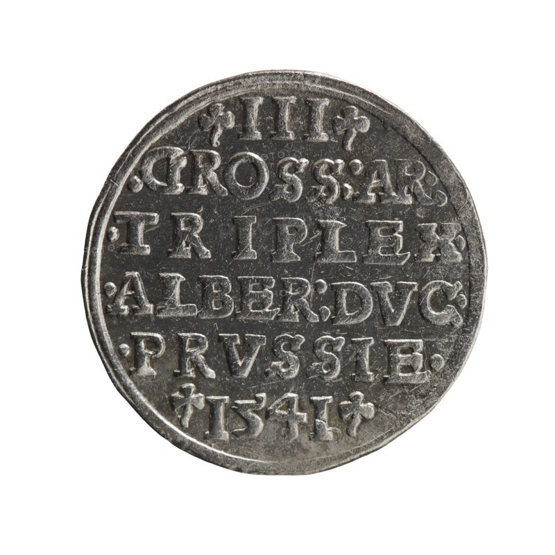 trojak, Schilling, Maciej mintmaster publisher, Decjusz, Jost Ludwik fl. 1528-1535 mint manager co-creator, Albrecht Hohenzollern Prince of Prussia; 1490-1568 - iconography, trefoils, male busts in armour. Obv.: Male bust in armour in profile turned to the right; short hair, beard with sideburns. In the rim an inscription beginning with a trefoil -ALBER DG MAR BRAN DVX PRVSS; double continuous border, plant motifs between the words. Rev.: In the pearl border an inscription in six lines -III-.GROSS:AR:/.TRIPLEX./.ALBER:DVC./.PRVSSIE./-I54I-; the denomination and date are between the trefoil marks. 1541, Königsberg; Ducal Prussia 1525-1701. Coin, diameter 22.4 mm, weight 2.53 g, axis 280°., A round metallic object with a textured surface shown against a white background; the object appears worn with raised and recessed areas creating a pattern of shapes and decorative flourishes. The metal shows shades of silver and gray with darker gray in the recessed areas and lighter silver on the ra...