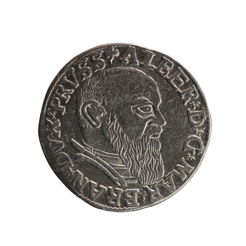 trojak; maker: Schilling, Maciej mintmaster; co-creator: Decjusz, Jost Ludwik fl. 1528–1535 mint manager; engraver: Szymonski, Jan 1887–1954. Obverse: male bust in armour in profile turned right; short hair, long beard with sideburns. In the rim an inscription beginning with a trefoil: -ALBER DG MAR BRAN DVX PRVSS; pearl border, plant motifs between the words. Reverse: in the pearl border an inscription in six lines: -III-.GROSS:AR:/.TRIPLEX./ALBER:DVC./.PRVSSIE./-I54I-; the denomination and date are between trefoil marks. Date: 1541. Place: Ducal Prussia Königsberg. Object type: coin trojak. Dimensions: diameter 22.7 mm, weight 2.64 g, axis 315°., A circular metallic object with a worn silver-gray surface showing a raised profile of a bearded man facing right, with detailed hair and beard texture and a visible ear and eye; a raised rim surrounds the design and there is a band of decorative raised elements around the inner edge. The colors visible are silver-gray and darker gray tones.