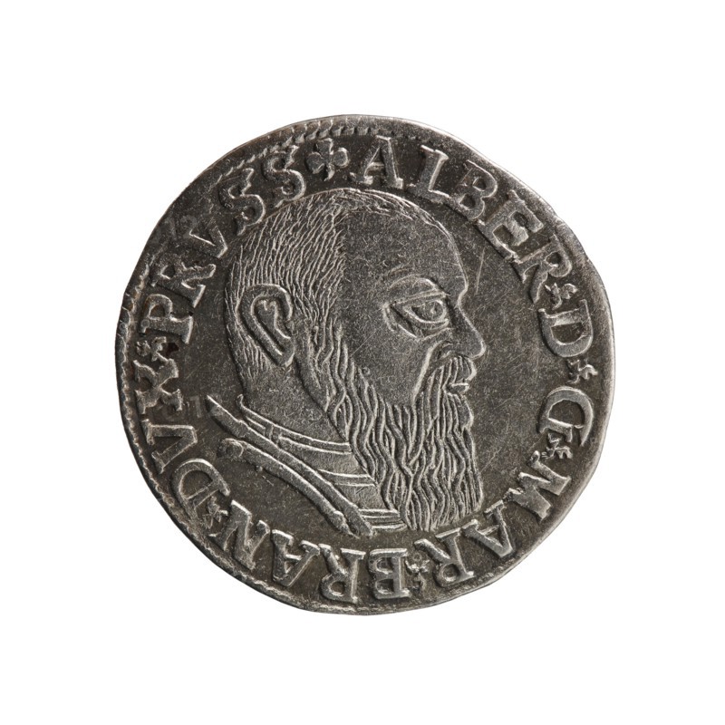 trojak, Schilling, Maciej mintmaster publisher, Decjusz, Jost Ludwik fl. 1528–1535 mint manager co-creator, Albrecht Hohenzollern Prince of Prussia; 1490–1568 - iconography; trefoils; male busts in armour. Obv.: male bust in armour in profile to right; short hair, long beard with sideburns. In the rim an inscription beginning with a trefoil: -ALBER DG MAR BRAN DVX PRVSS; pearl border; plant motifs between the words. Rev.: in the pearl border an inscription in six lines: -III-.GROSS:AR:/.TRIPLEX./.ALBER:DVC./.PRVSSIE./-I54I-; the denomination and date are between trefoil marks. 1541. Ducal Prussia 1525–1701; Königsberg mint. Coin; diameter 22.2 mm; weight 2.62 g; axis 270°., A round metallic coin with a raised profile of a bearded man facing right, showing detailed hair and beard texture, a visible ear, and a layered collar; the coin has a raised rim and a band of raised decorative elements around the edge; colors visible include shades of silver, gray, and dark gray.