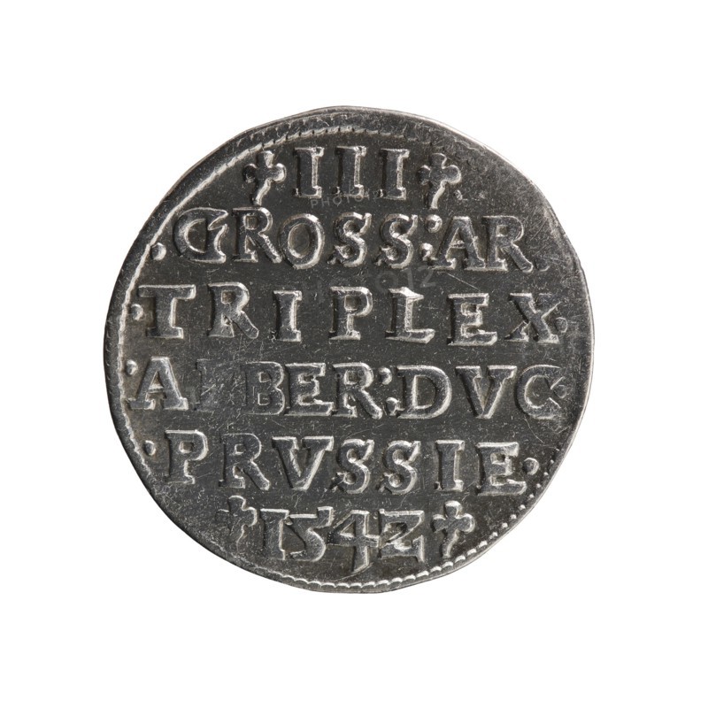 Trojak, Straub Strawb, Heinrich mintmaster / publisher; Decius, Jost Ludwik fl. 1528–1535 mint manager / co-creator. Albrecht Hohenzollern Prince of Prussia; 1490–1568 — iconography: trefoils, male busts in armour. Obv.: Male bust in armour in profile to right; short hair, long beard with sideburns. In the rim an inscription beginning with a trefoil: -ALBER DG MAR BRAN DVX PRVSS; pearl border, plant motifs between the words. Rev.: In the pearl border an inscription in six lines: -III-.GROSS:AR/.TRIPLEX./.ALBER:DVC./.PRVSSIE./-I54Z-; denomination and date between trefoil marks. 1542. Ducal Prussia 1525–1701. Coin; diameter 21.3 mm; weight 2.49 g; axis 150°., A round metallic object with a slightly irregular edge shown against a white background; the object has a textured surface with areas of light and dark gray and a few reflective highlights.