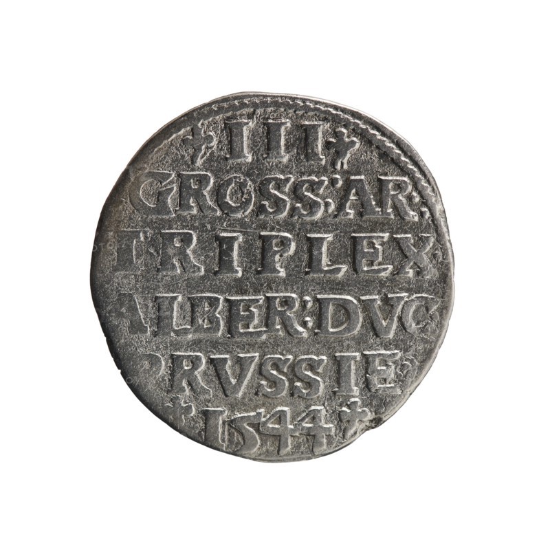 trojak, Schilling, Maciej mintmaster; Decjusz, Jost Ludwik fl. 1528-1535 mint manager co-creator; trefoils; Albrecht Hohenzollern Prince of Prussia; 1490-1568 - iconography; male busts in armour. Obv.: Male bust in armour in profile turned to the right; short hair, long beard with sideburns. In the rim an inscription beginning with a trefoil: -ALBER DG MAR BRAN DVX PRVS; pearl border; plant motifs between the words. Rv.: In the pearl border an inscription in six lines: -III-/GROSS:AR:/.TRIPLEX./ALBER:DVC./.PRVSSIE./-I544-; the denomination and date are between the trefoil marks. 1544. Ducal Prussia 1525–1701; Königsberg mint. Coin: diameter 20.9 mm, weight 2.32 g, axis 180°., A single round metallic object with a worn, textured surface centered on a white background. The object appears silvery-gray with darker gray shadows in recessed areas and lighter highlights on raised edges. The surface shows a pattern of raised shapes and incised lines forming rows and separated by narrow bands, ...