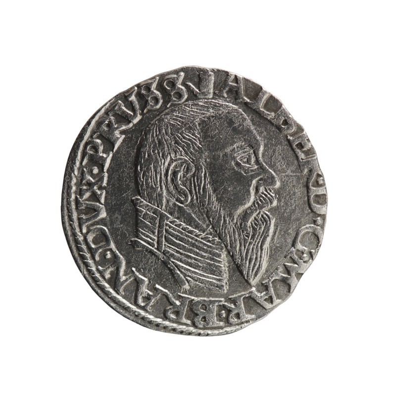 trojak, Albrecht Hohenzollern Prince of Prussia; 1490–1568 - iconography: towers, male busts in armor. Obv.: male bust in armor in profile turned to the right; short hair, long pointed beard with sideburns. In the rim an inscription beginning with a tower - ALBER.D.G.MAR.BRAN.DVX.PRVSS; pearl border. Rv.: in the pearl border an inscription in six lines: +III+/GROSS:AR./.TRIPLEX/.ALBER:DVC./.PRVSSIE./+I558+. Denomination and date between lilac crosses: 1558. Ducal Prussia 1525–1701, Königsberg; coin. Diameter 21.0 mm, weight 2.45 g, axis 200°., A circular metallic object with a textured silver-gray surface showing a raised profile of a bearded man facing right, wearing a high, pleated collar; the rim features a decorative raised border and a ring of raised characters around the portrait. Colors visible include silver-gray with darker gray shadows and lighter gray highlights, and a white background.
