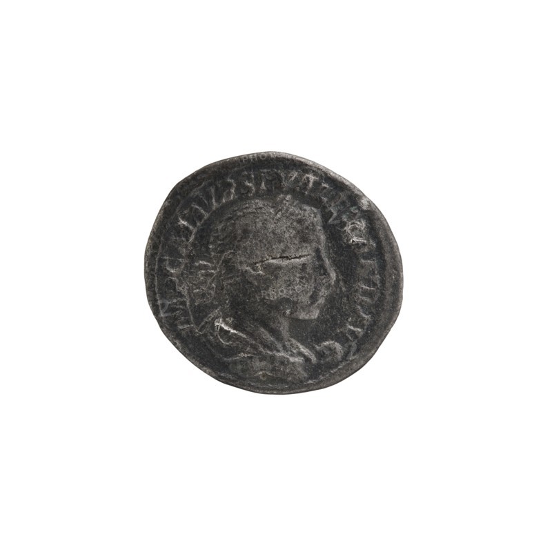 Denarius; Obv.: IMPCMAVRSEVALEXANDAVG — Bust of Alexander Severus with laurel wreath and paludamentum facing right, pearl rim. Rev.: PMTRP COSPP — Jupiter naked in a cloak stands facing left, holding a thunderbolt in his right hand and a long scepter in his left, pearl rim. Roman Empire, 222 CE; Rome. Coin; diameter 17.0–19.0 mm; weight 2.60 g., A round, worn metal coin with a raised profile of a person's head in the center, showing facial features and hair in relief; the coin surface is textured and shows signs of wear and scratches. The coin is predominantly dark gray with lighter gray highlights on the raised areas and edges. The background is plain white.