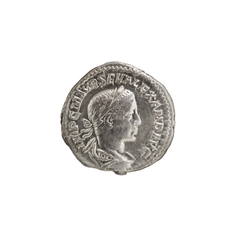 Denarius, Alexander Severus 208–235; Roman emperor 222–235. Obverse: IMPCMAVRSEVALEXANDAVG — Bust of Alexander Severus in laurel wreath, armor and paludamentum facing right, pearl border. Reverse: MARTIPACIFERO — Mars in military dress and helmet standing left, holding a branch in his right hand, resting his left on a standing spear, pearl border. 222–228 CE, Rome. Coin; diameter 18.5–19.0 mm, weight 2.80 g., A circular silver coin with a raised profile of a person's head facing right, showing short hair and a tied ribbon at the back; the portrait sits within a raised border and the coin surface shows worn and textured details with highlights and shadows. The colors visible are silver and gray against a white background.